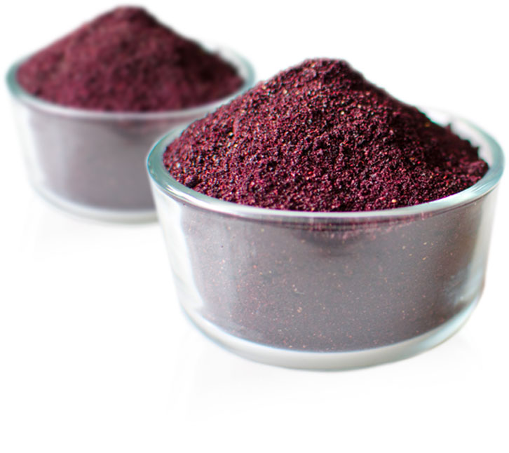 A glass bowl filled with powdered wild blueberries.