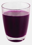 A drinking glass filled with dark purple wild blueberry juice.