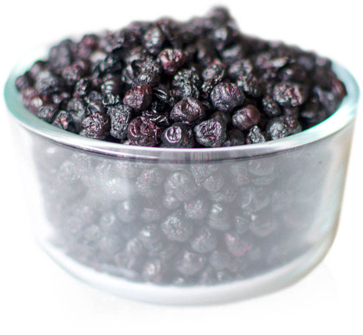 A glass bowl filled with dried crunchy wild blueberries.