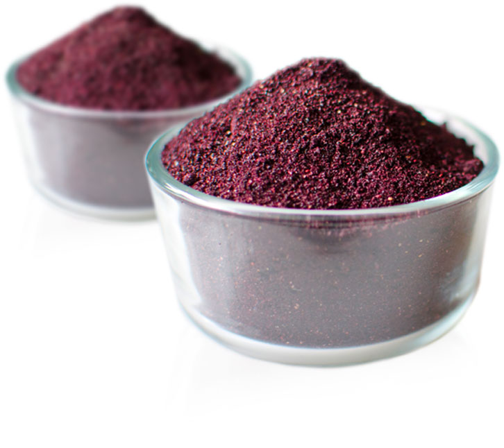 A glass bowl filled with powdered wild blueberries.